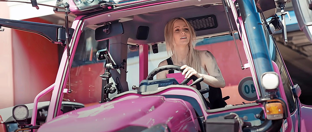 Melissa in een roze Lindner-trekker (Foto: Youtube-video van Melissa Naschenweng - Traktorführenschein)
