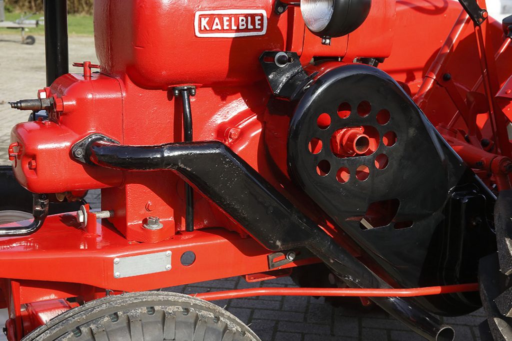 De motor is met bouten in sleufgaten op het frame gemonteerd. Met de stelbout voorop schuif je de motor op om de V-snaren op spanning te zetten.