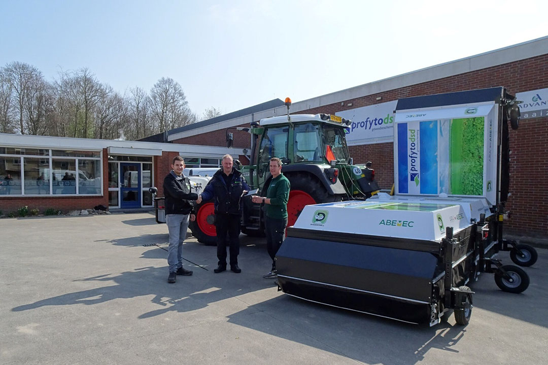 Gerton Wullink, chef werkplaats van Abemec (rechts), en Han Hilbrands, hoofd operations van Doorgrond.nl, (links) overhandigen de tablet van de EcoRobotix ARA aan Marc van Dijk van ProfytoDSD. - Foto: Abemec