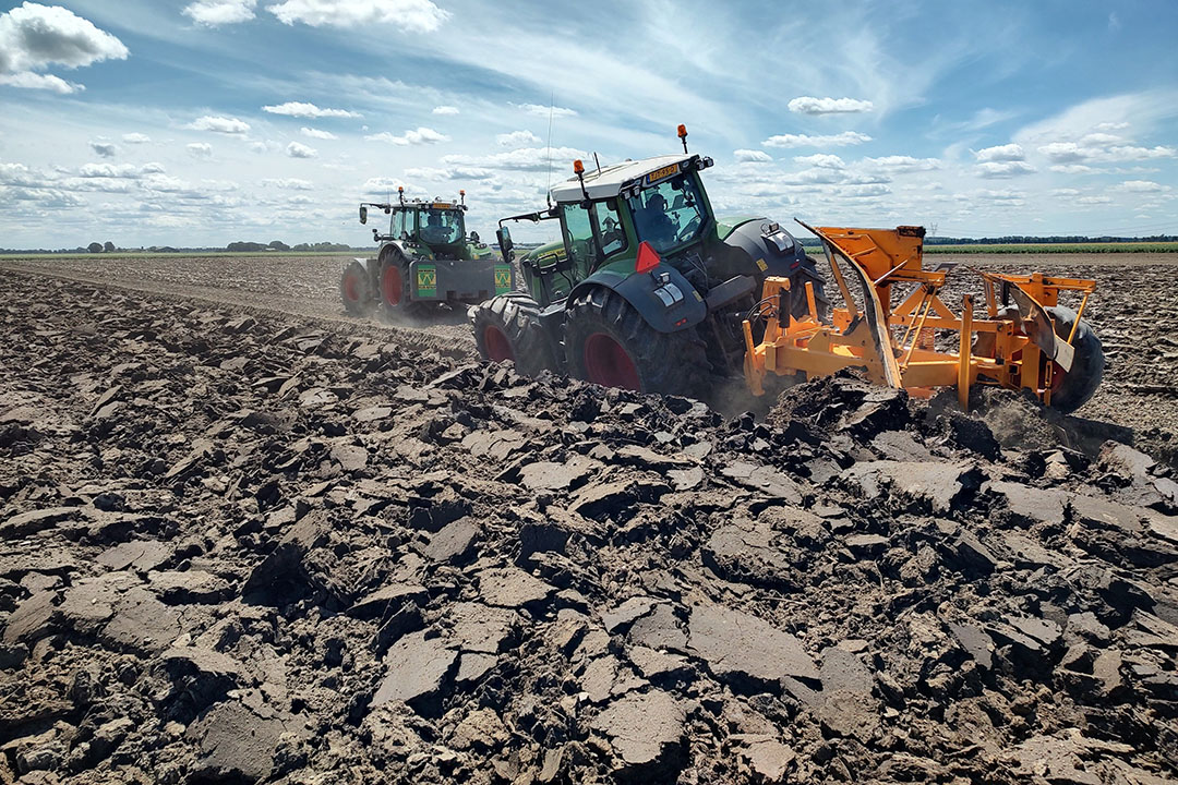 Van Werven Infra & Recycling heeft een sterkere 1,20 m diepploeg gebouwd. Met twee Fendt-trekkers van het type 718 Vario en 939 Vario en een gezamenlijk trekvermogen van bijna 600 pk, is Van Werven aan het diepploegen in Dronten. Een vrachtwagenband hangt tussen de twee kettingen om schokken op te vangen. - Foto: Van Werven Infra & Recycling