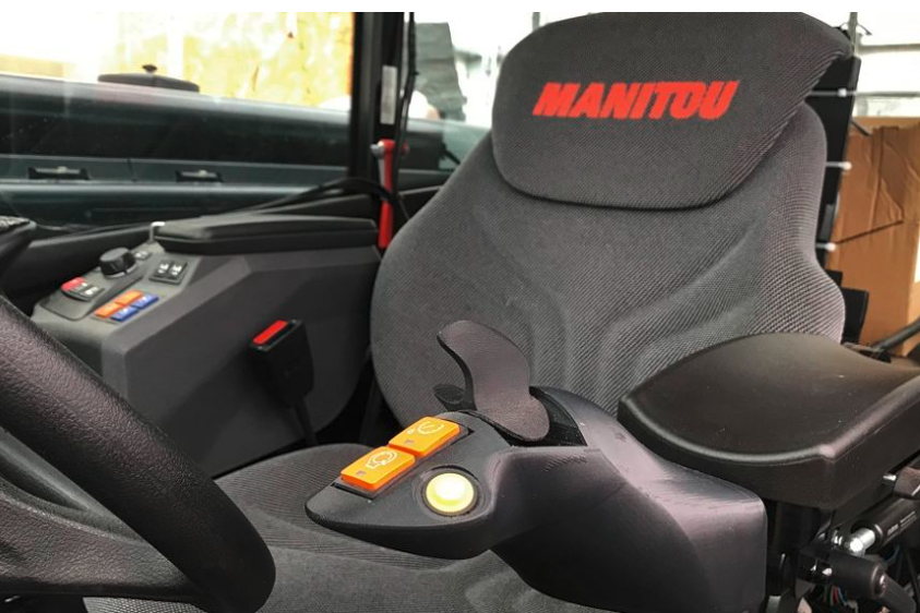 De arm van de chauffeur rust op de armleuning tijdens het werken met de Manitou Steering Ministick. 
