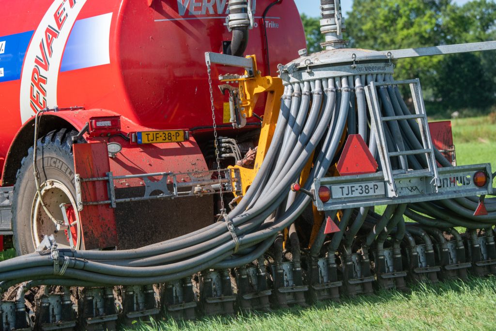 Als door een gedragen werktuig in de hefinrichting van een trekker of zelfrijder de kentekenplaat niet zichtbaar is, moet je een witte volgplaat op het werktuig monteren. Dit is ook zo bij geregistreerde getrokken voertuigen met iets in de hef, zoals een getrokken mesttank. Die heeft vanwege de registratie een eigen gele GAIK-plaat. Vaak is deze door de aangekoppelde bemester niet meer zichtbaar. Op de zoden- of bouwlandbemester hoort dan een witte volgplaat te zitten. Met deze combinatie mag je gewoon 40 km/u rijden. – Foto: Michel Velderman