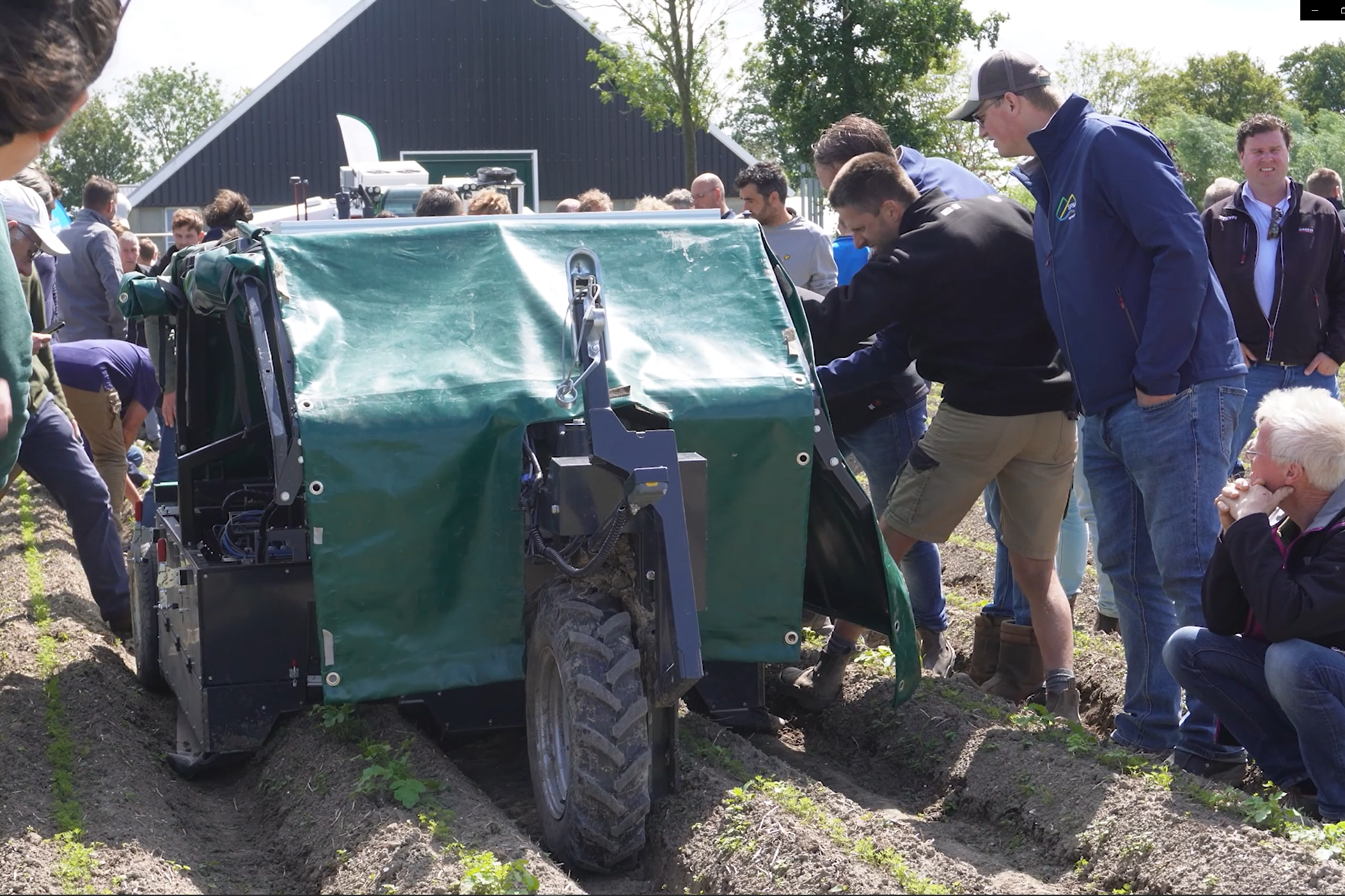 Bezoekers op de Biovelddag 2024 in Lelystad bekijken tijdens de machinedemo’s wiedrobot Trabotyx. – Still uit video