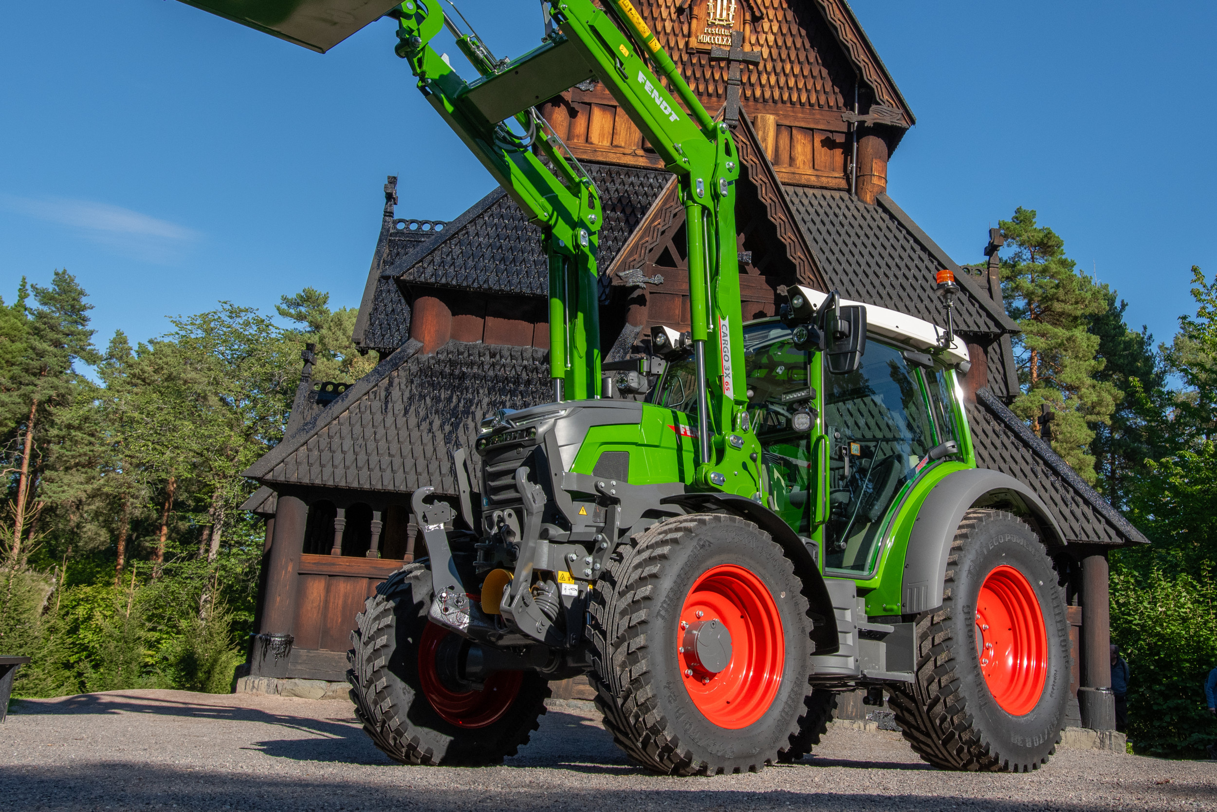 De nieuwe elektrische Fendt e107 Vario poseert voor een 2.100 jaar oude kerk in het Noorse volksmuseum tijdens een persevenement in Bygdøy. Deze nieuwste toevoeging aan het portfolio van Fendt is rijp voor de verkoop. Fendt levert de trekkers als eerste in Nederland, Duitsland en Noorwegen. – Foto: Jacco van Erkelens