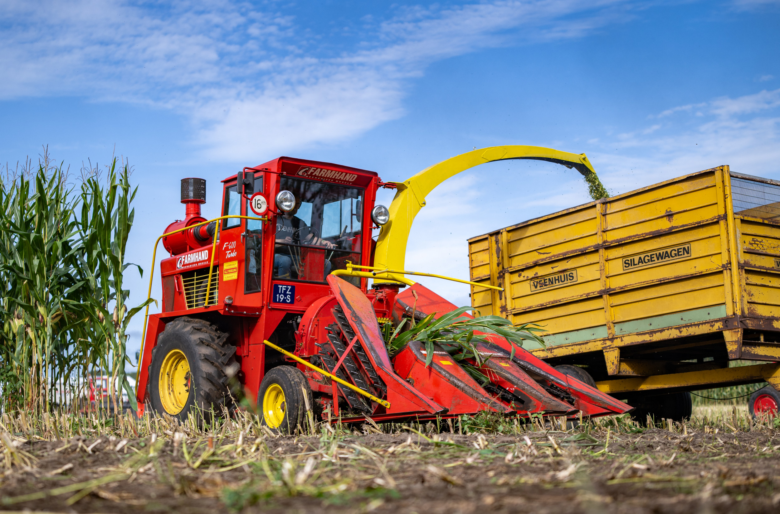 Wim Lamberts (65), gepensioneerd contractbeheerder bij Unica, demonstreert zijn goede werkende hakselaar Farmhand F600. “Wat het hakselen betreft kan de F600 zich nog steeds meten met de moderne machines. Een luxe stoel, hydrostatische aandrijving, zelfs airco in de cabine!” – Foto’s: Michel Velderman