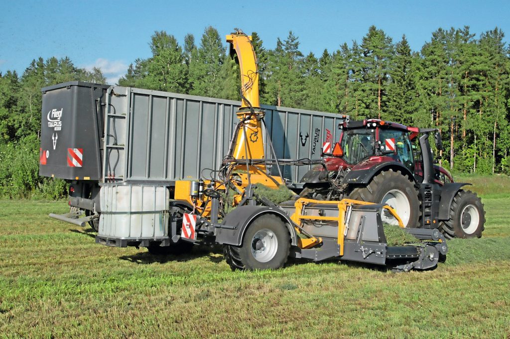 Ondanks de variabele vochtigheid en zwadvorm waren er geen problemen met de pick-up en de invoer tijdens de test. Het IBC-vat (water/toevoegmidddelen) staat op palletvorken. Je kunt het optillen met een hydraulische cilinder. Zicht erop heb je via de camera op de blaaspijp. – Foto: Bas van Hattum