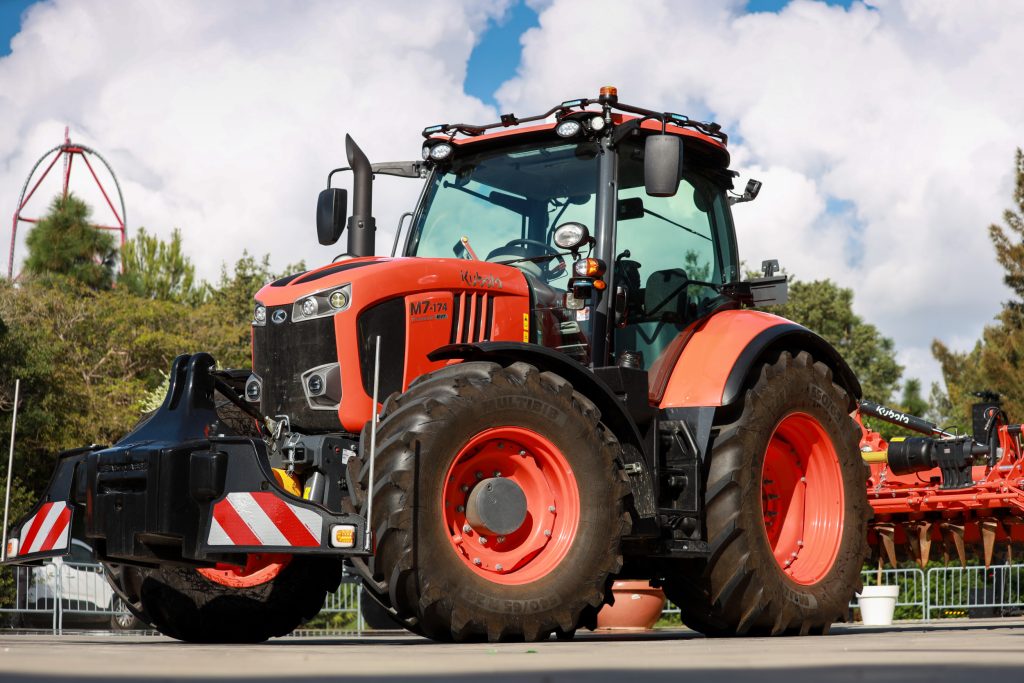 Kubota demonstreert de werking van de opbouwkit op een nieuwe M7004-serie. De trekker rijdt hier zonder chauffeur over een parkeerterrein, waarbij ook de hefinrichting en aftakas automatisch werken.