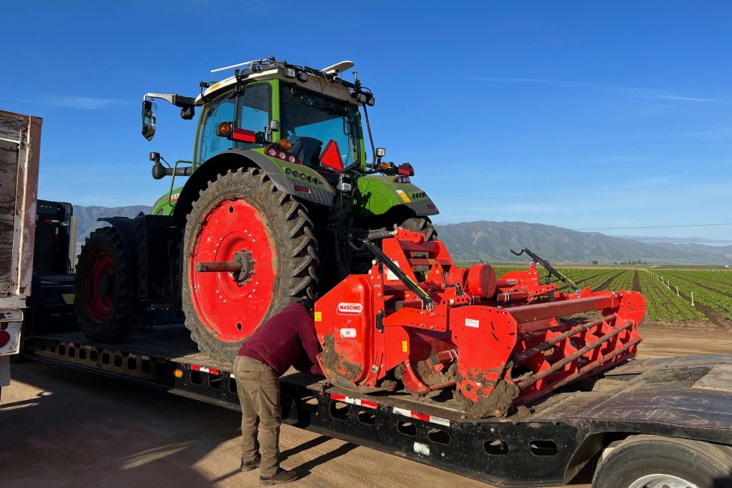 Hier zie je een autonome trekker vastgezet met kettingen om hem van het ene perceel naar de andere te verplaatsen. Eén keer per week is dit geen probleem, maar als dit elke dag moet gebeuren, zou je er gek van worden. Let op: de tractor staat op een dieplader die wordt getrokken door een vrachtwagen. Hiervoor heb je iemand met een CDL nodig, en dat begint een uitdaging te worden in de VS. Walmart werft vrachtwagenchauffeurs met een jaarsalaris van $100.000 (€92.000). – Foto: Sabanto