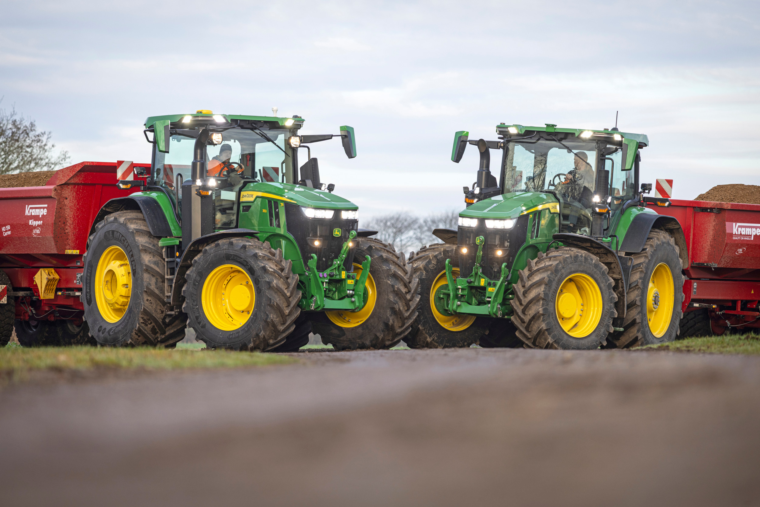 Links de John Deere 7R 350 en rechts de 7R 290 met erachter Krampe-kippers. TREKKER onderwerpt deze twee Amerikaanse John Deere's uit de 7R-serie aan een uitgebreide transporttest, met twee soorten transmissies en vering. – Foto’s: John Christensen, Lars Holm