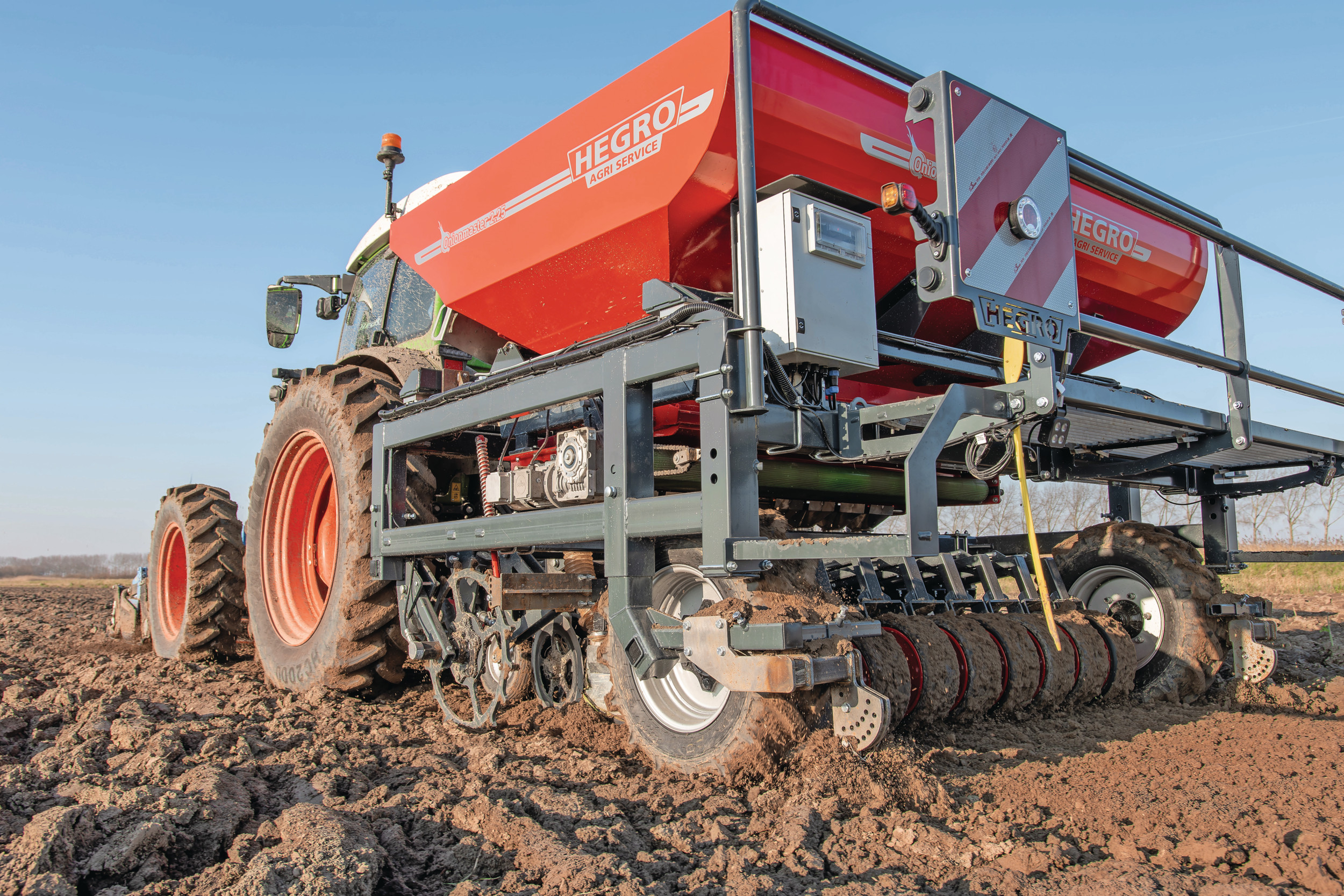 Uien poten gebeurt meestal met twee personen of meer: iemand in de trekker en nog iemand achter op de pootmachine. Met de HeGro Onionmaster kan de chauffeur vanuit de cabine zelfstandig uien planten. – Foto’s: Jacco van Erkelens