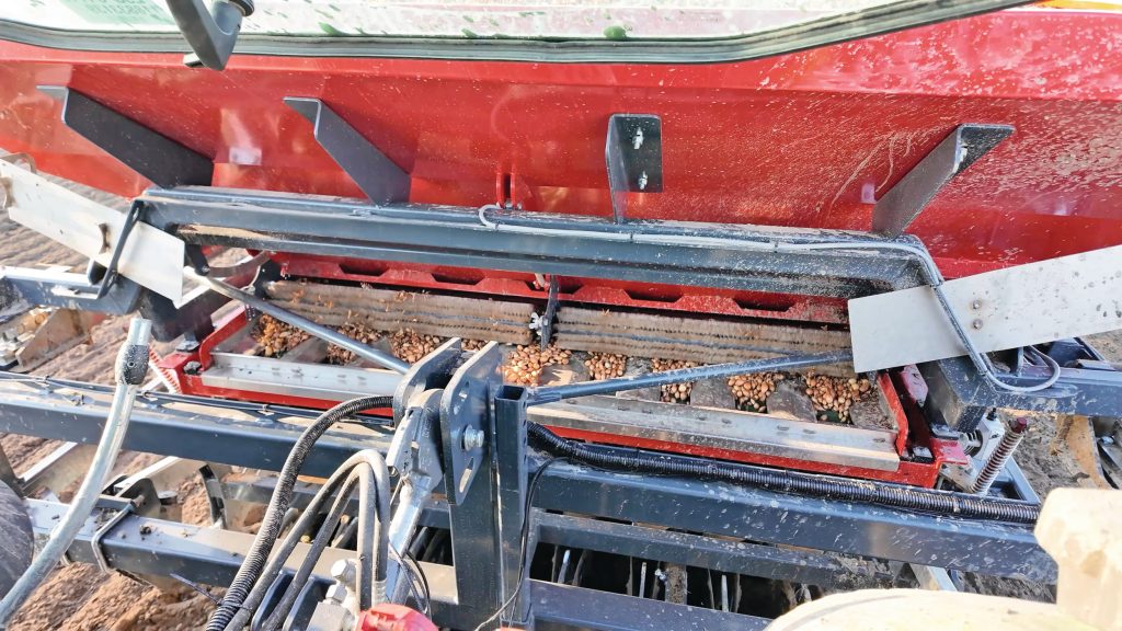 Vanuit de cabine heb je zicht op de schudplaten en de band. Van hieruit kun je elektronisch de schuiven openen, waarmee ook de roterende borstel beweegt. Zo heb je de juiste dikte van uien op de band liggen.