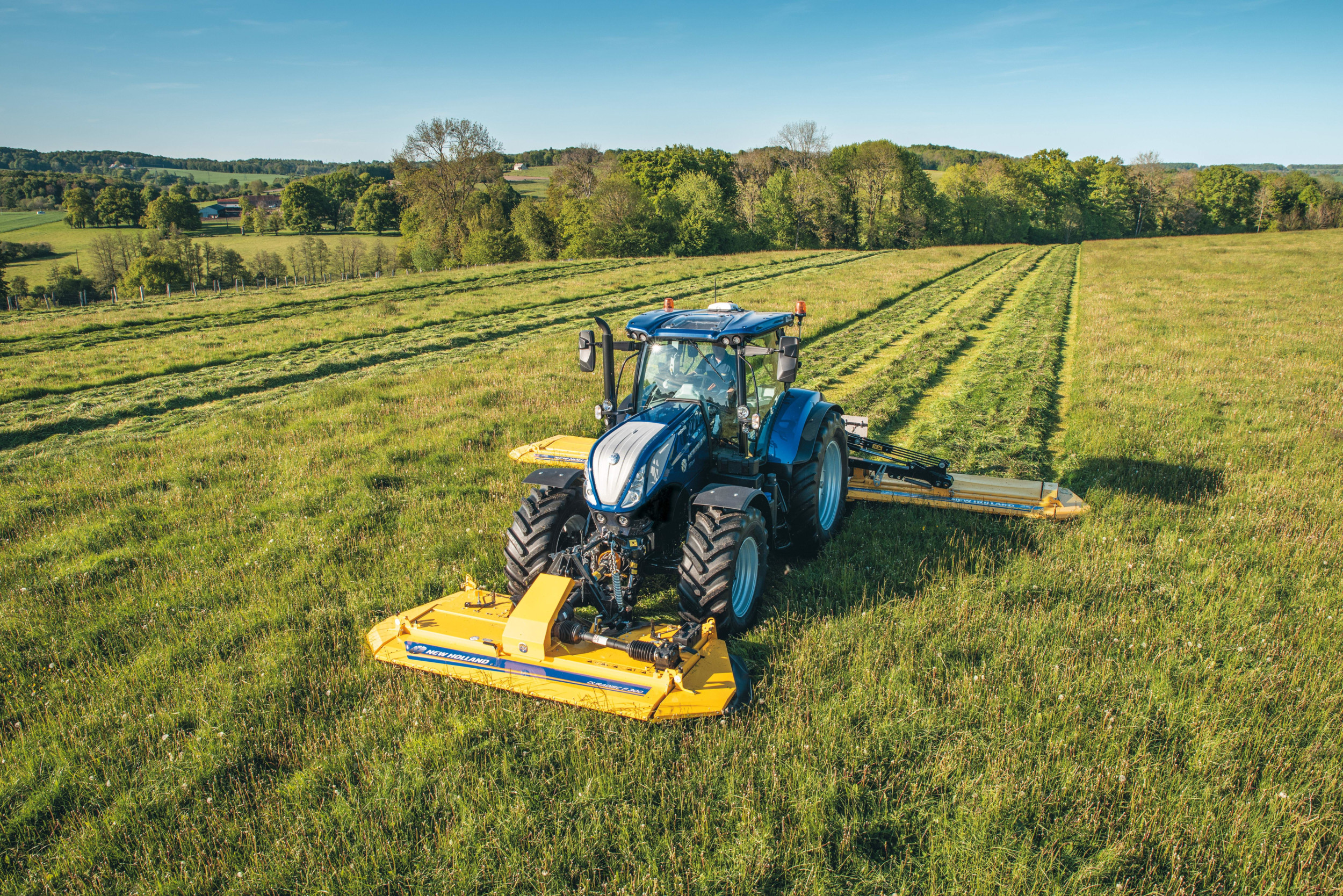 Een New Holland T7-trekker met triplemaaier van Maschio Gaspardo in New Holland-kleuren. De Italiaanse machinefabrikant Maschio Gaspardo gaat New Holland-maaiers, -schudders en -harken leveren in de kleurstelling van New Holland. – Foto: New Holland