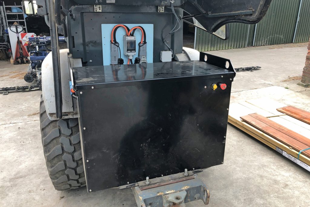 De standaard AGM-loodaccu van de Kramer-wiellader (80 volt, 25 kWh) maakte plaats voor deze 54 kWh lithium-ijzer-fosfaataccu van Jarocells. Er is nog een tweede van, die in een handomdraai kan worden gewisseld. De behuizing staat vast met twee klemstukken (onderin).