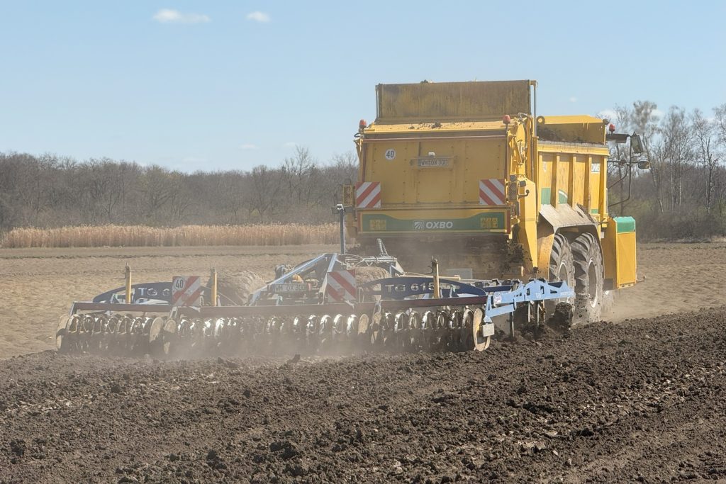 De vaste mest breed uitstrooien en direct inwerken kan met de getrokken cultivator achter de Oxbo AT 5105-meststrooier. Zo is er minder kans op bodemverdichting en verslemping van de grond.