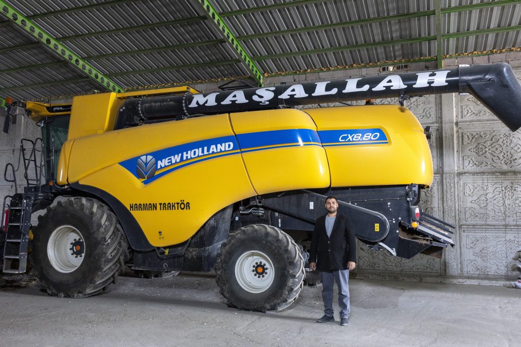 Akmul Altintas bij de New Holland CX8.80-maaidorser uit 2023. De machine dorst jaarlijks zo’n 1.000 uur. Let ook op de fraaie patronen op de muren. De tekst ‘Masallah’ op de pijp betekent ‘bescherming tegen het boze oog’.