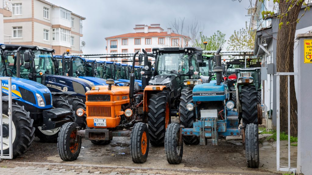 Helemaal vooraan twee Turkse-licentietrekkers. Links een Türk Fiat 640, rechts een Hema (Ford) 5875. Volgens Tayat zijn deze Hema-trekkers nooit populair geweest in Turkije, en stopte Hema al snel met de productie.