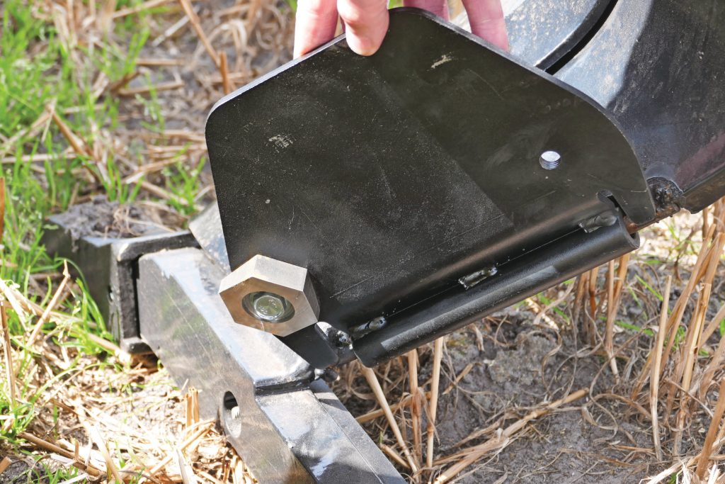 De plaat achter op de woeltanden is met een moer aan de onderkant traploos in hoogte in te stellen.