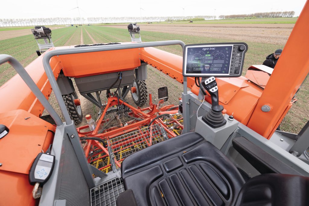 De bestuurder heeft veel zicht op het werk. Rechts het digitale dashboard/boordcomputer voor de belangrijkste instellingen. Rijden en bedienen van de hydraulische functie doe je met de joystick. De knoppen zijn vrij programmeerbaar.