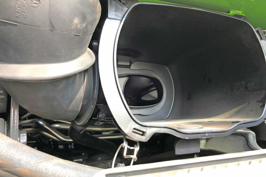 Dit is de luchtfilter-behuizing onder de cabine. Via een 12 bar lucht-puls (luchtschok) blaast deze het stof los waarna het stof via een slang richting de koelvin wordt afgezogen en naar buiten wordt geblazen. Hetzelfde principe zit in het motor-luchtfilter. Beide zijn opties.