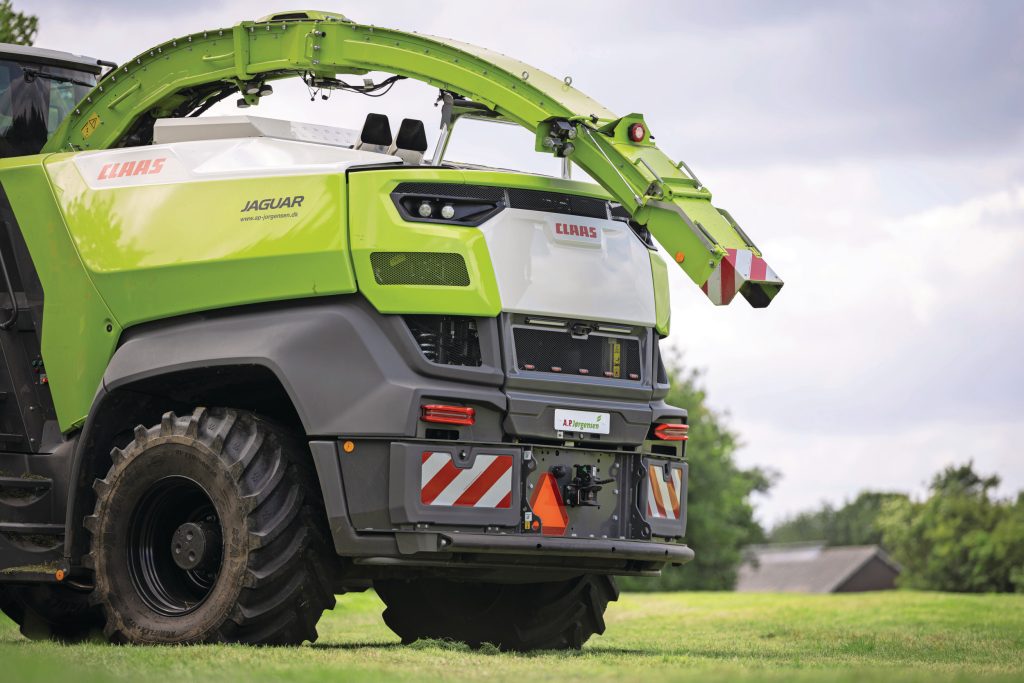 De hakselaar is voorzien van een nieuw uiterlijk. Detail: voor wie met het nieuwe veertienrijige-voorzetstuk gaat hakselen, is er een langere, opklapbare pijp.