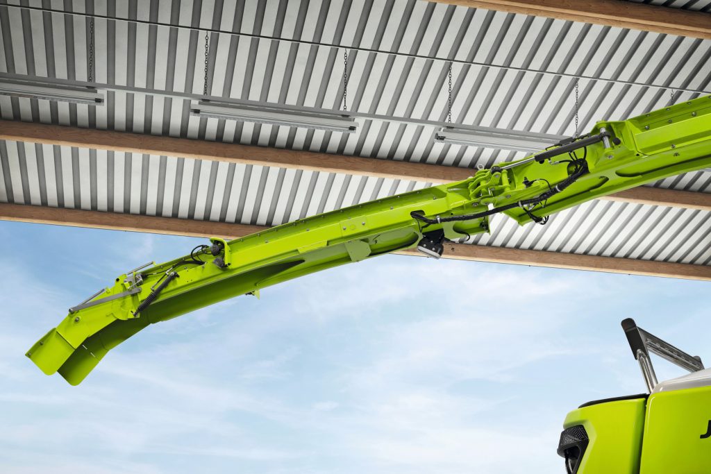 Bij een breed voorzetstuk, hoort een lange pijp. Deze kan opvouwen voor het transport, zodat-ie niet te ver achter de machine uitsteekt.