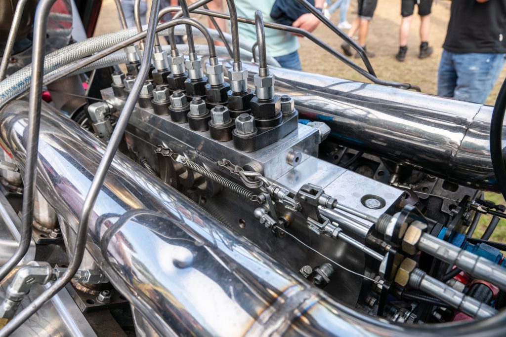 De dikke brandstofpomp staat midden tussen beide cilinderbanken, en is bij de V8 bijna net zo lang als het motorblok.