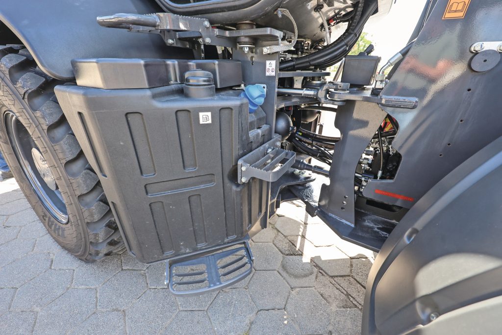 De aandrijfas loopt centraal door het knikpunt. Links de ietwat kwetsbaar ogende kunststof dieseltank, gecombineerd met de AdBlue-tank.