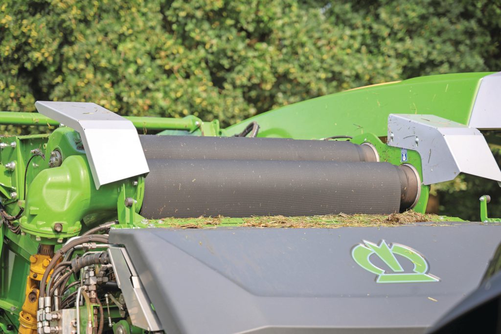 Om slip te voorkomen zijn er drie aangedreven rollen waar de persband tussendoor slingert. Voorafgaand werkt een vijzelachtige rol in lastige omstandigheden aangekoekt gewas naar buiten.