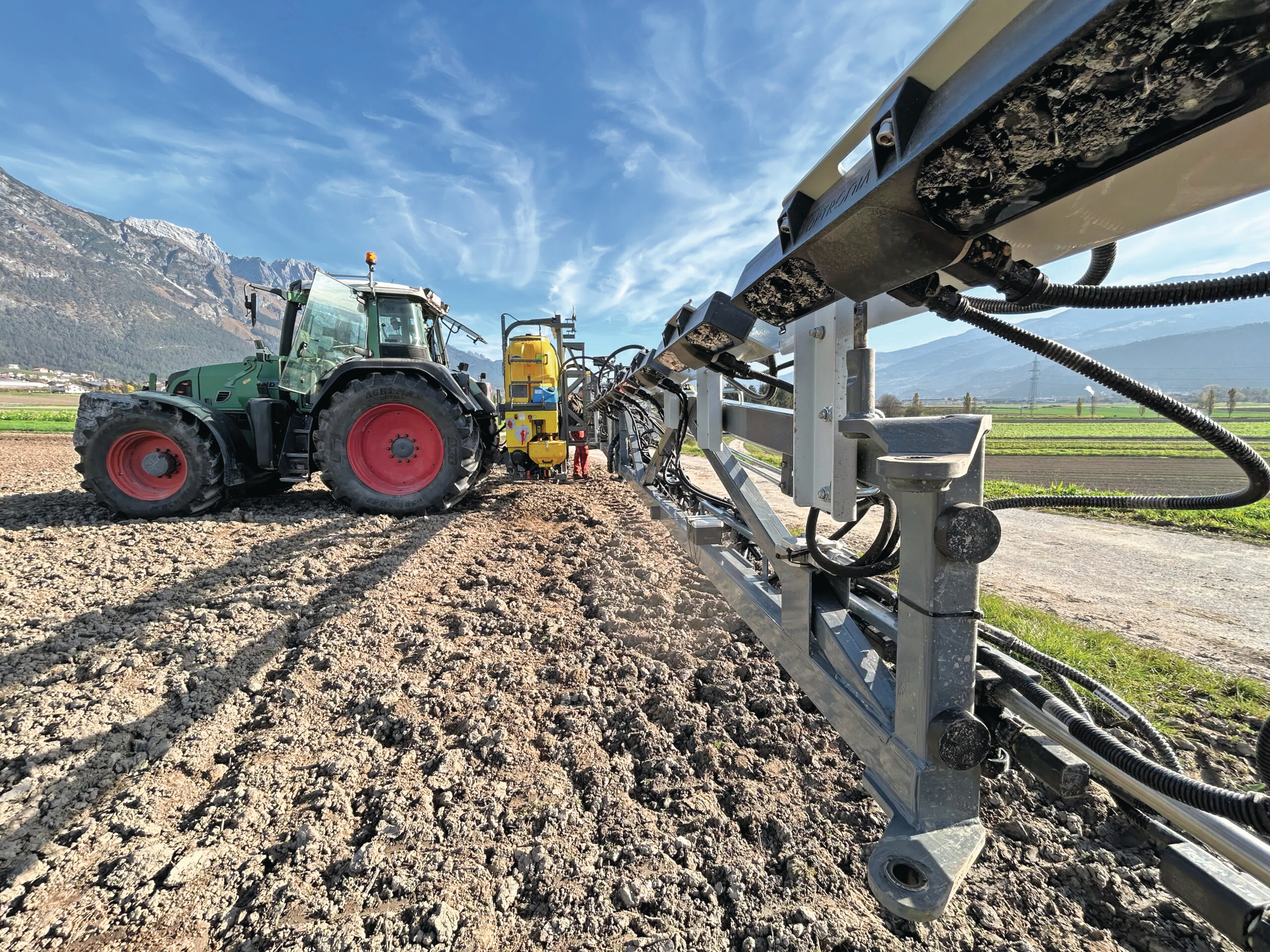 Spraylogics toont zijn OptiMist-sensorsysteem, dat spuitmachines uitrust met realtime plantdetectie via NIR-sensoren. NIR betekent Nabij InfraRood-spectroscopie. Een NIR-sensor meet tijdens de werkzaamheden continu en maakt het resultaat van een meting direct bekend, zodat de teler onmiddellijk kan bijsturen. Het systeem herkent bladerdichtheid, plantgrootte en onderdelen als stam, bladeren, bloemen en vruchten. Ook stuurt het elke spuit afzonderlijk aan. Zo wordt precies de juiste hoeveelheid middel toegepast waar nodig, wat leidt tot minder gebruik van chemicaliën, lagere kosten en meer duurzaamheid in boom- en wijngaarden. Foto: Spraylogics