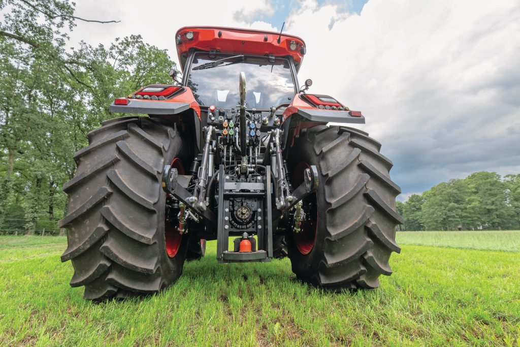 De achterzijde van de trekker oogt wat rommelig vanwege zichtbare leidingen en slangen en de verhoudingsgewijs ver naar achteren geplaatste hefarmen.