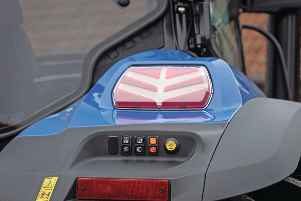 Fraai detail: de nieuwe led-achterlichten zijn in de vorm van het New Holland-logo. Je kunt met de spatbordbediening ook het toerental bedienen of de motor uitzetten.