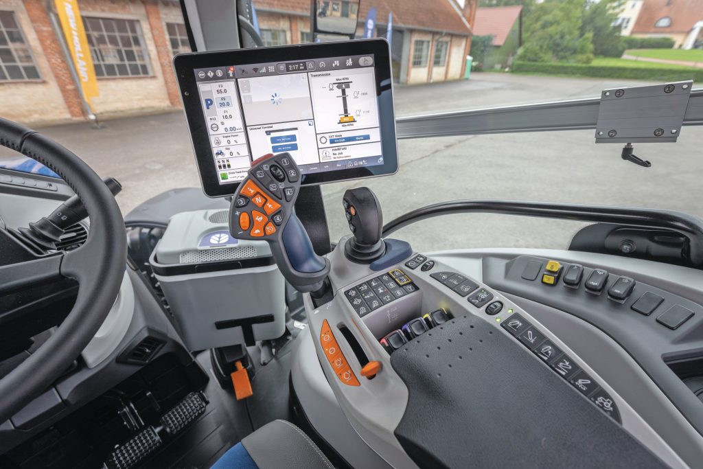 De armleuning is wat smaller gemaakt, zodat de stoel evengoed kan draaien ondanks de kleinere cabine. Let ook op de optionele koelkast, rechtsvoor in de cabine.