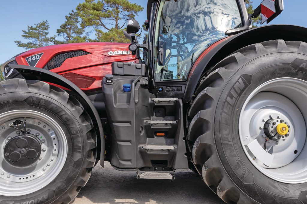 De instap is lekker ruim, met degelijke treden en voorzien van verlichting en stekker- en luchtaansluitingen. Ook hier is een gereedschapskist geplaatst. Let trouwens op de achterwielen: 750/70 R44.