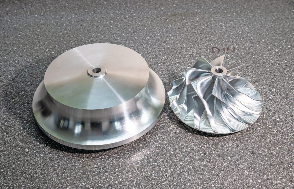 Links een massief stuk aluminium, rechts het 'billet' compressorwiel dat uit dit aluminium wordt gefreesd.