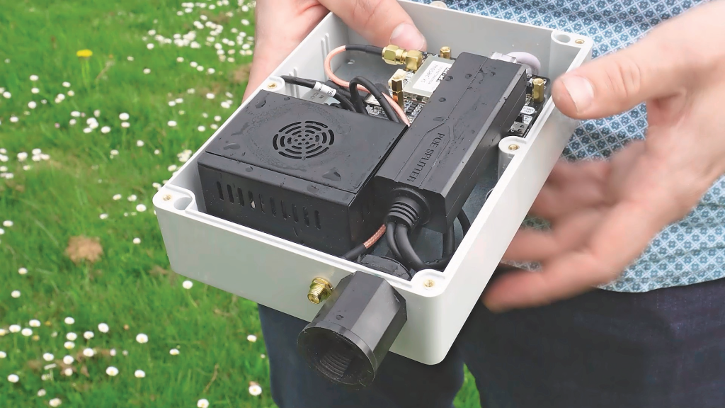 Déjan Pöstgens van GroeiSamen/De Innovatie Coöperatie toont welke componenten zijn zelfgebouwde basisstation bevat. Die zijn aangemeld bij het netwerk van de Franse nonprofit-organisatie Centipede-RTK, dat een netwerk met basisstations beheert voor gratis RTK-correctie. Foto: Paulus Maessen