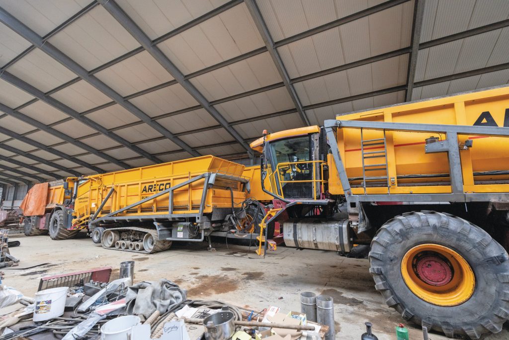 Veel capaciteit in de schuur! Links in beeld: de eerste aanschaf, de Vredo VT4556 uit 2005 met strooieropbouw. In het midden: één van de twee Areco-hooglossers op rupsen, zoals die aangekocht zijn op de veiling. En rechts: de zelfrijdende hooglosser.