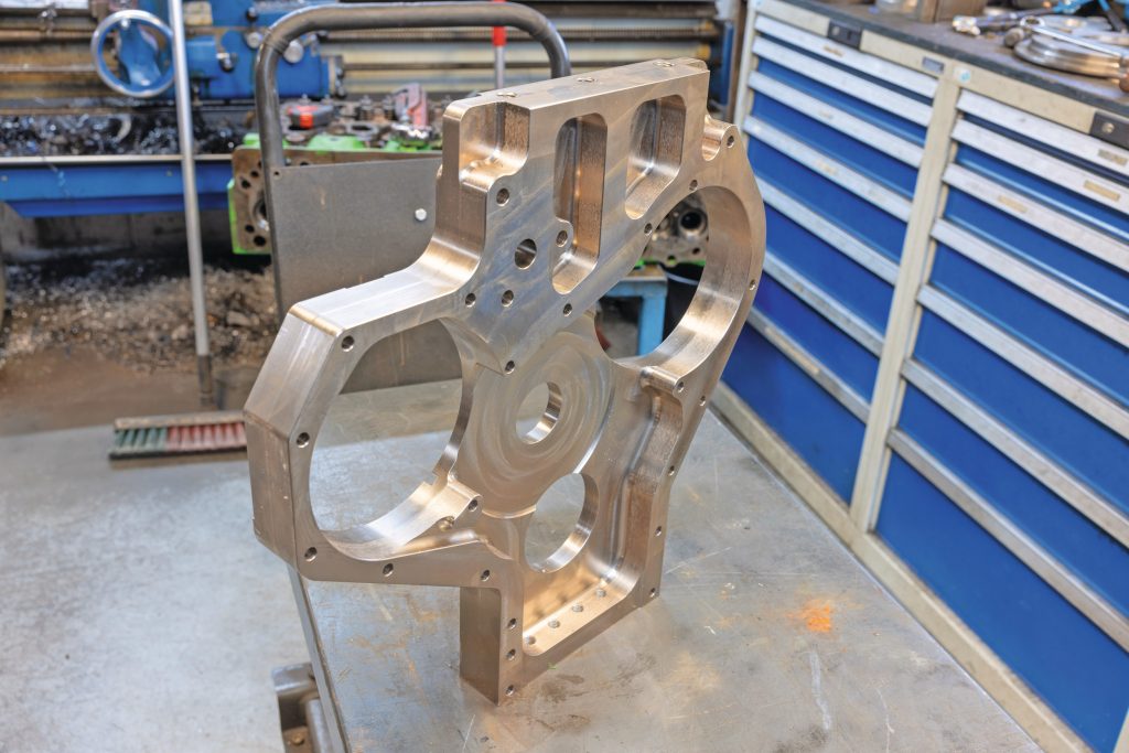 De techneuten ontwikkelden deze stalen distributieplaat. Hij zit voor aan de motor en voorkomt dat het motorblok gaat scheuren. Foto: Peter Roek