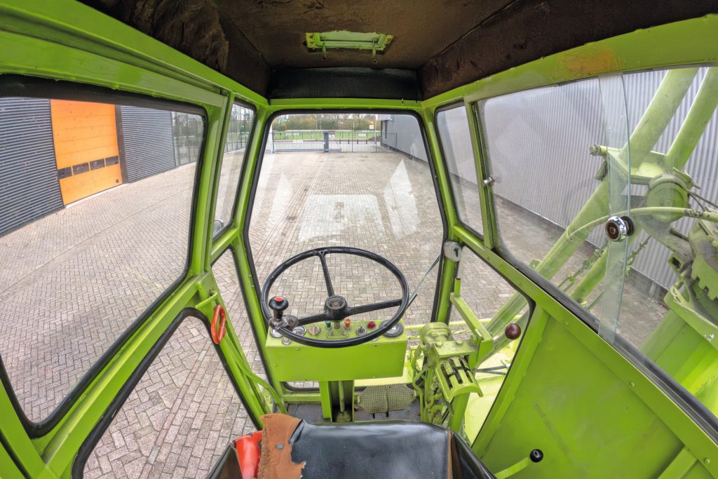 Machinist Harrie Jans-Beeken herinnert zich de spartaanse, rumoerige cabine en eenvoudige bediening met H-patroon voor hydraulische functies.