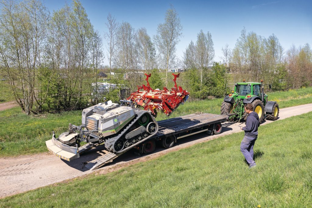 Voor transport over de openbare weg is een dieplader nodig. Prettig werken vraagt een dieplader/wipkar met hydraulisch opklapbare rijplaten. Is wel een extra investering van €20.000 tot €30.000.